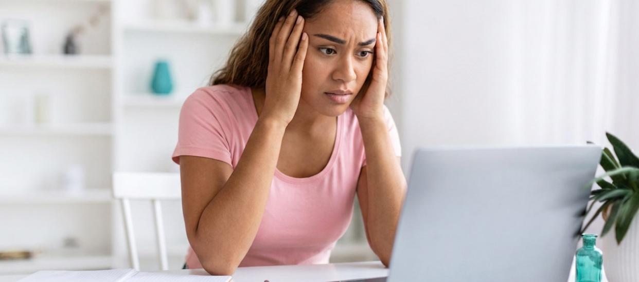 Femme stressée en consultant ses comptes sur son ordinateur