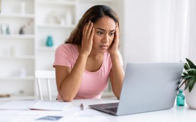 Femme stressée en consultant ses comptes sur son ordinateur